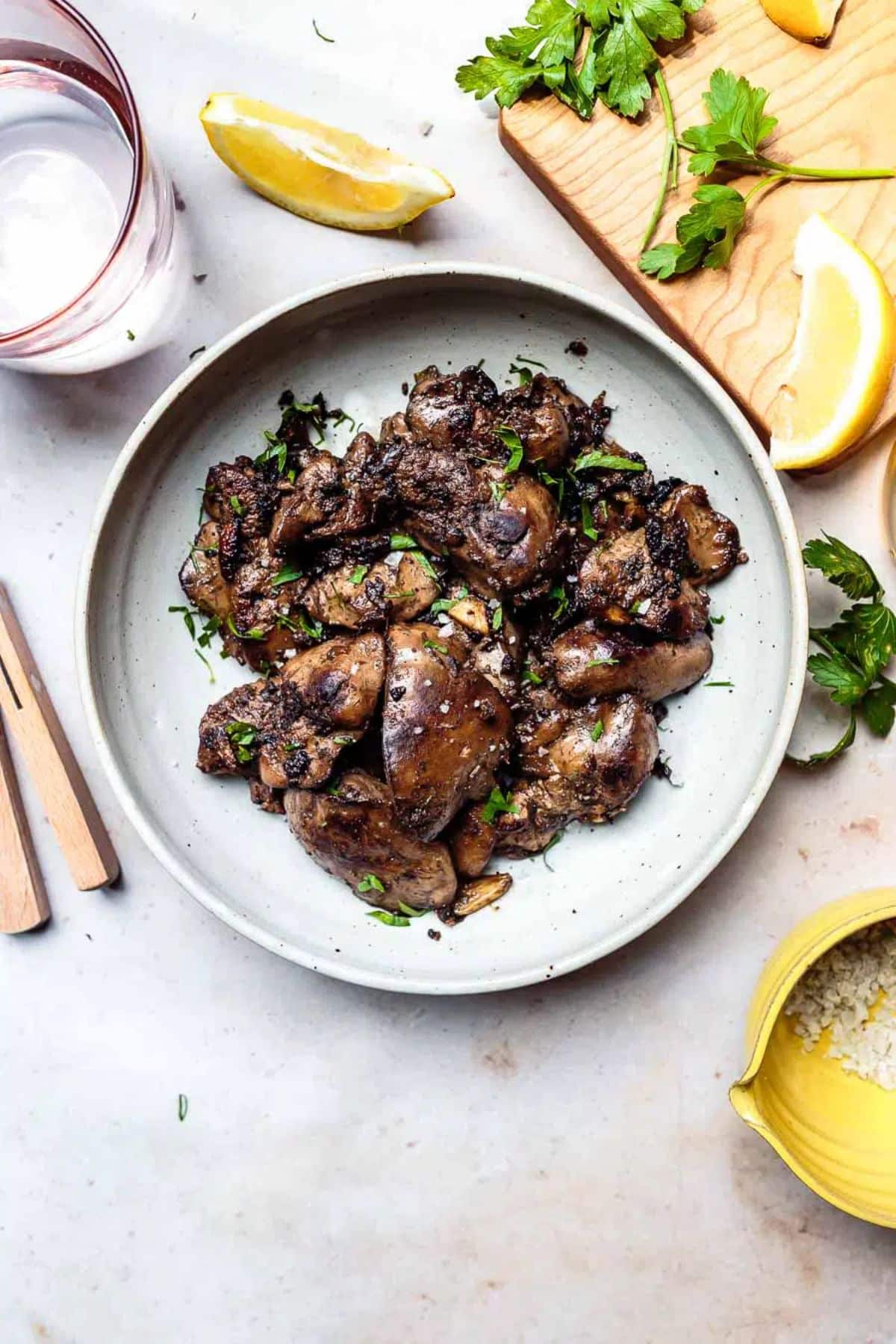 Juicy Sauteed Lemon-Garlic Chicken Liver and Onions on a white plate.
