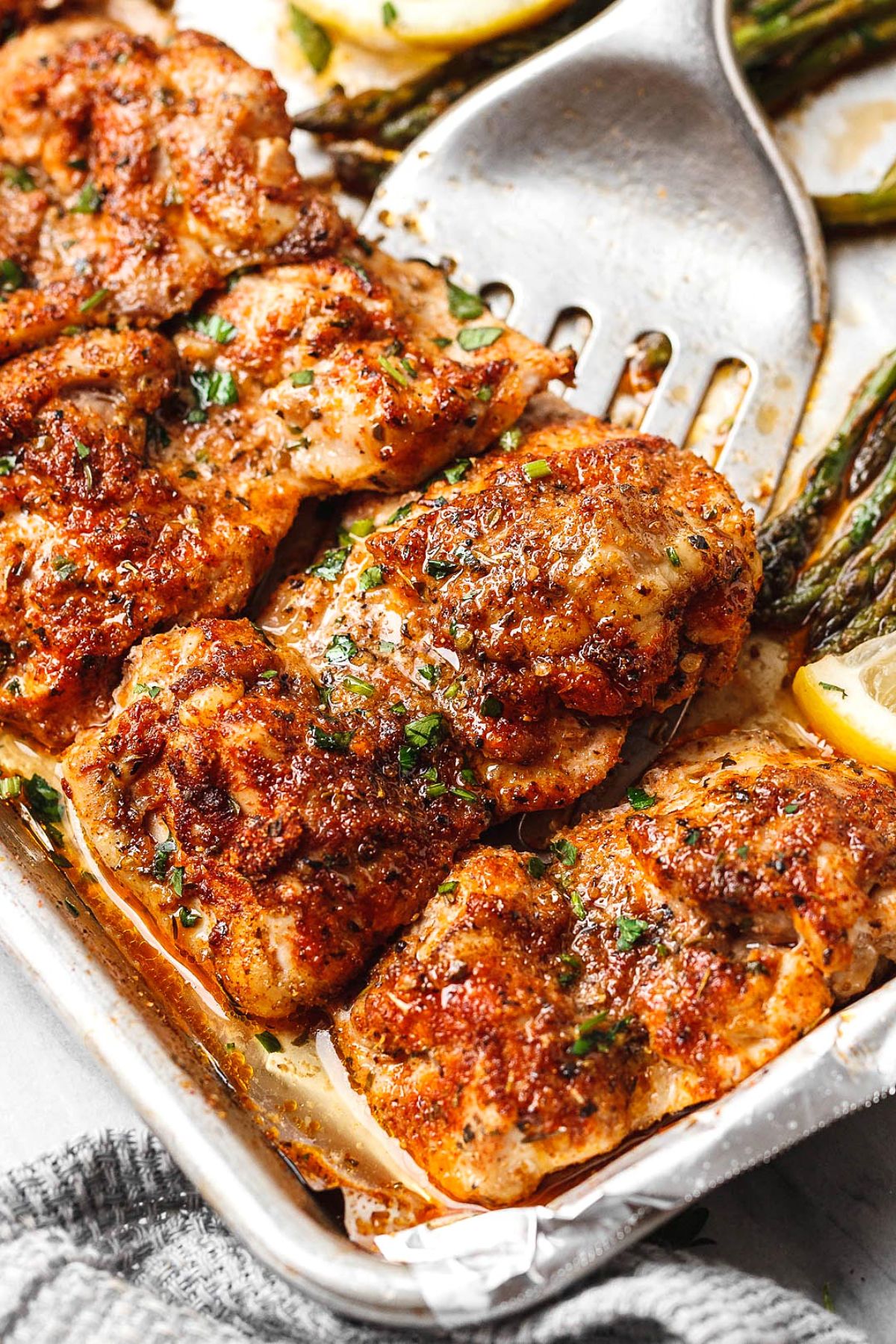 Juicy gluten-free Best Oven-Baked Chicken on a baking tray picked with a spatula.