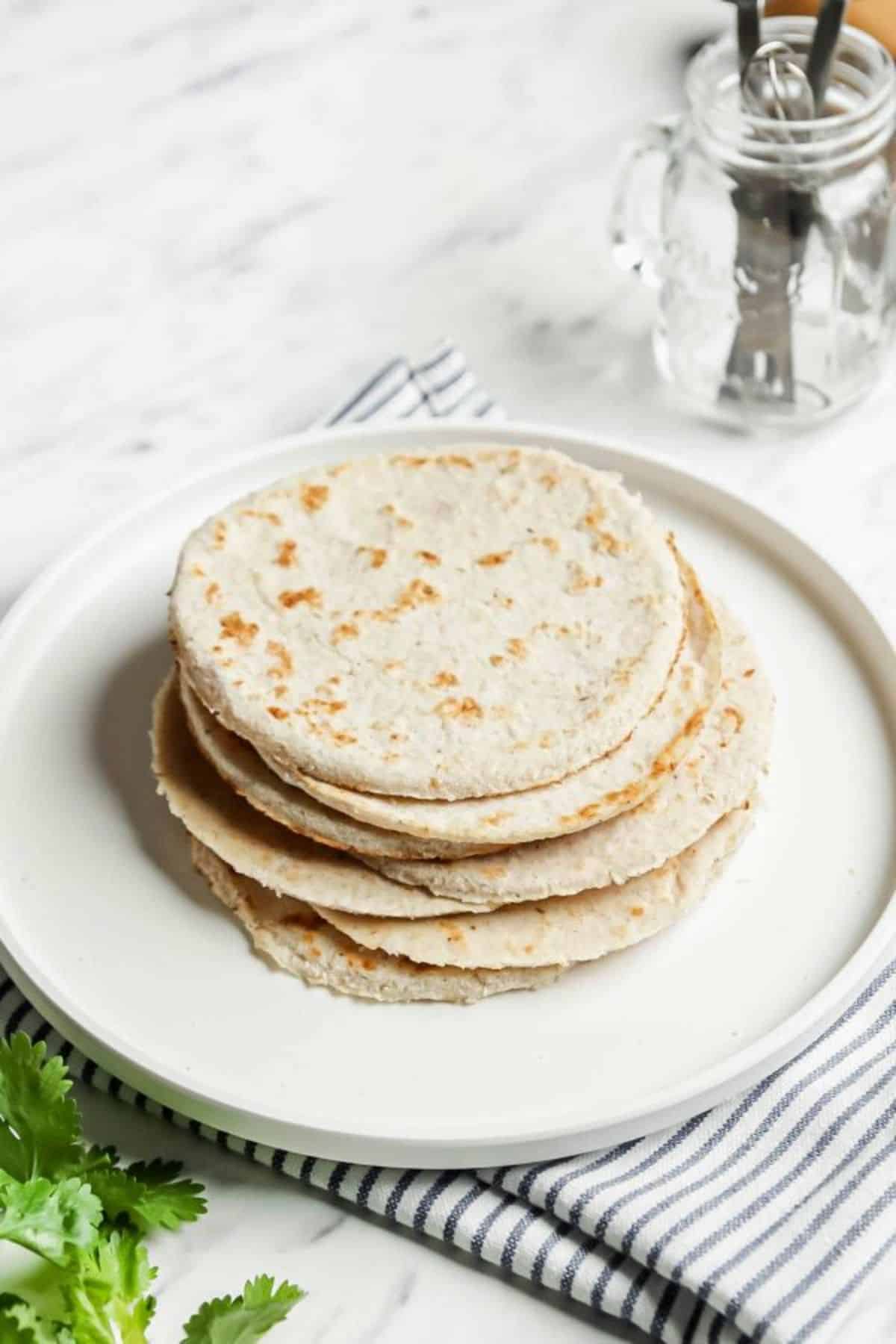A pile of Coconut Flour Tortillas on a white plate.