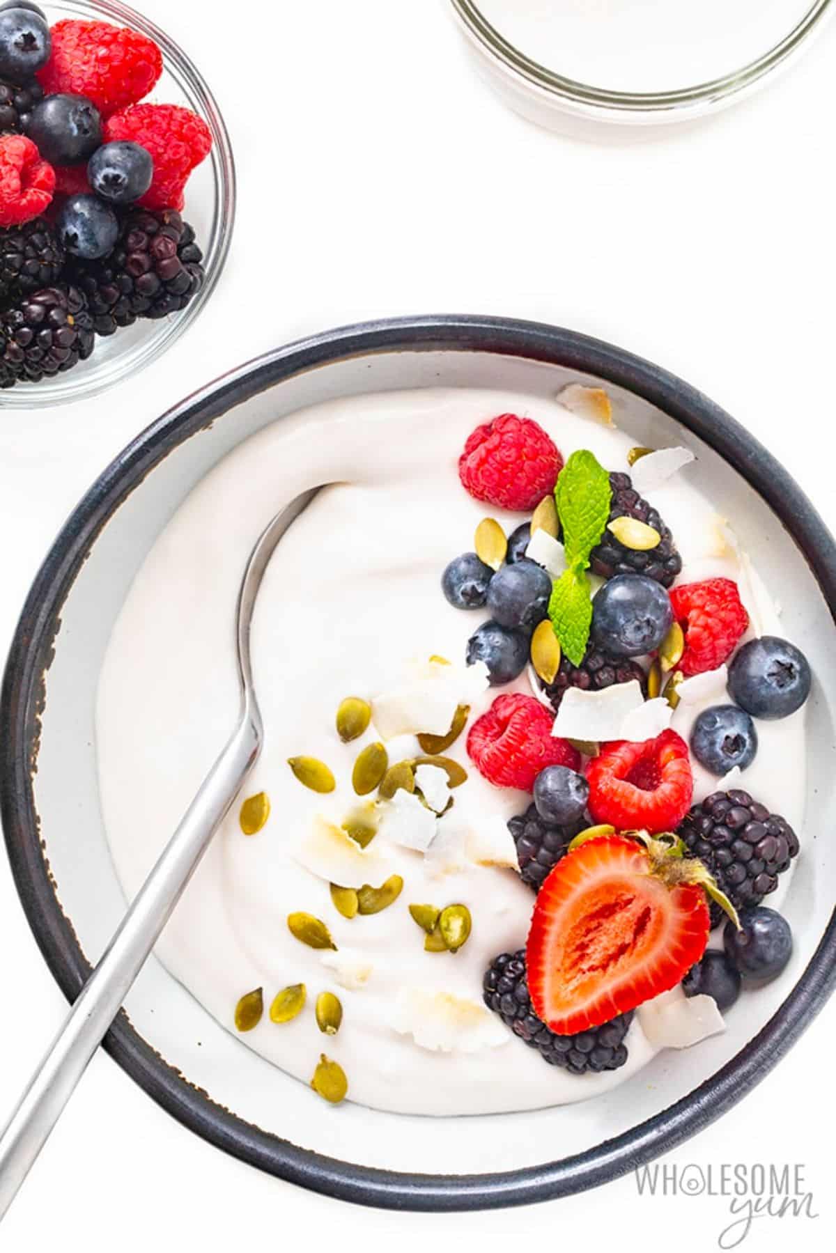 Healthy Coconut Yogurt with fruits in a bowl with a spoon.