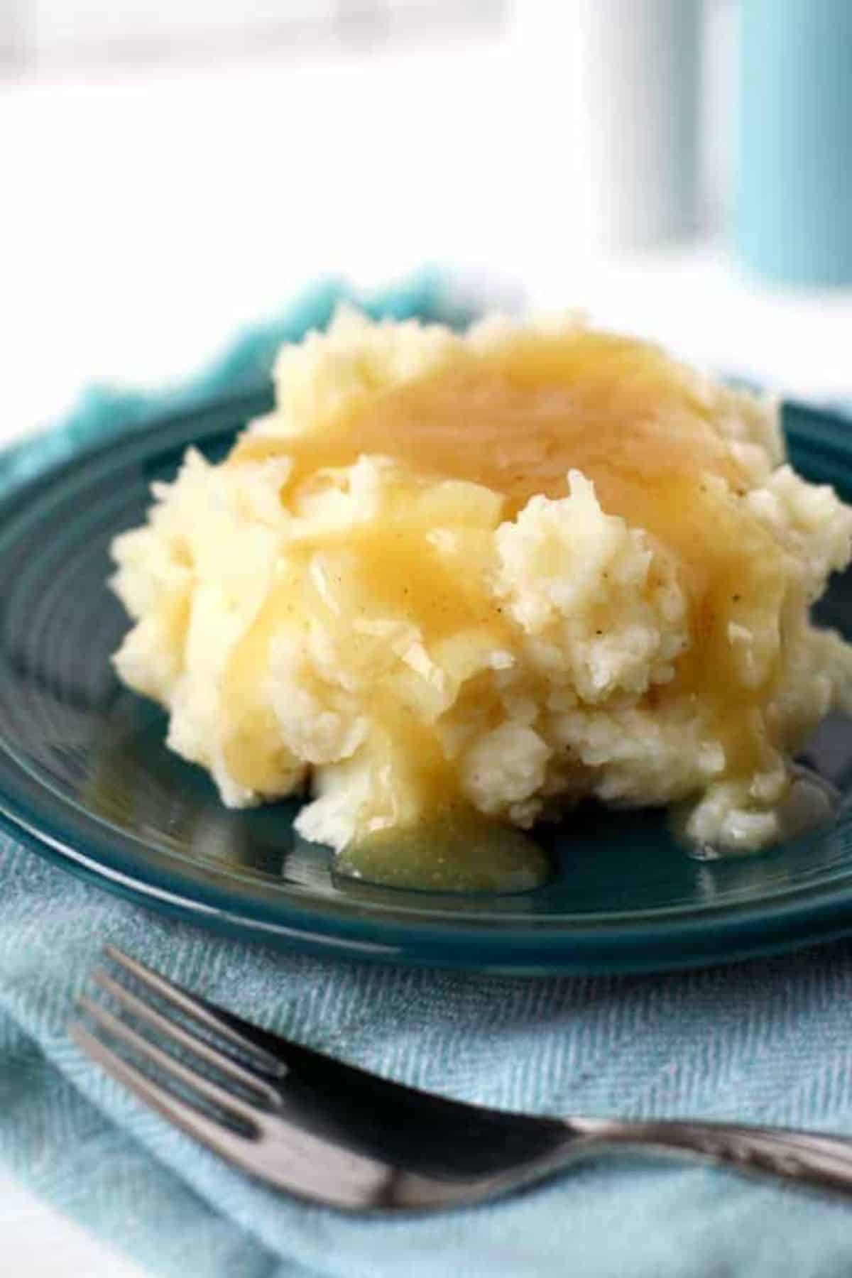 Tasty Easy Gluten-Free Gravy on mashed potatoes on a blue plate.
