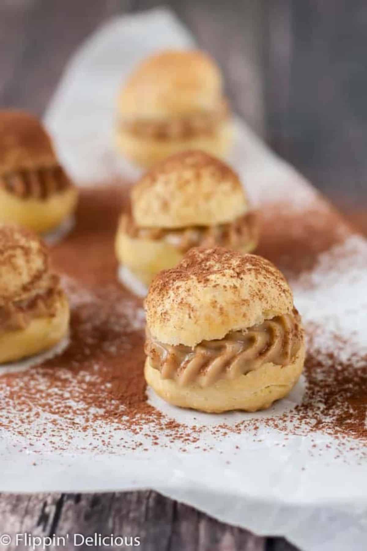 Flavorful Tiramisù Cream Puffs on a wooden table.