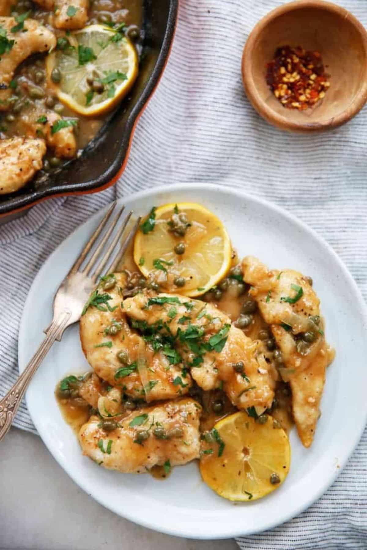Flavorful 30-Minute Gluten-Free Chicken Piccata on a white plate with a fork.