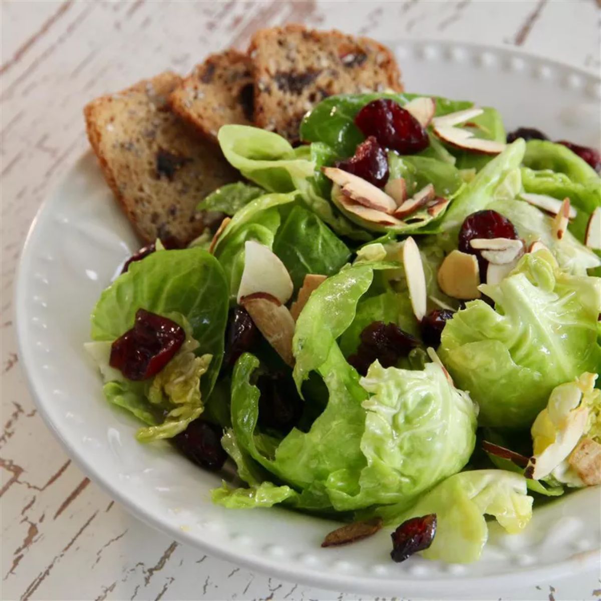 Healthy Maple Dijon Brussels Leaf Salad on a white plate.