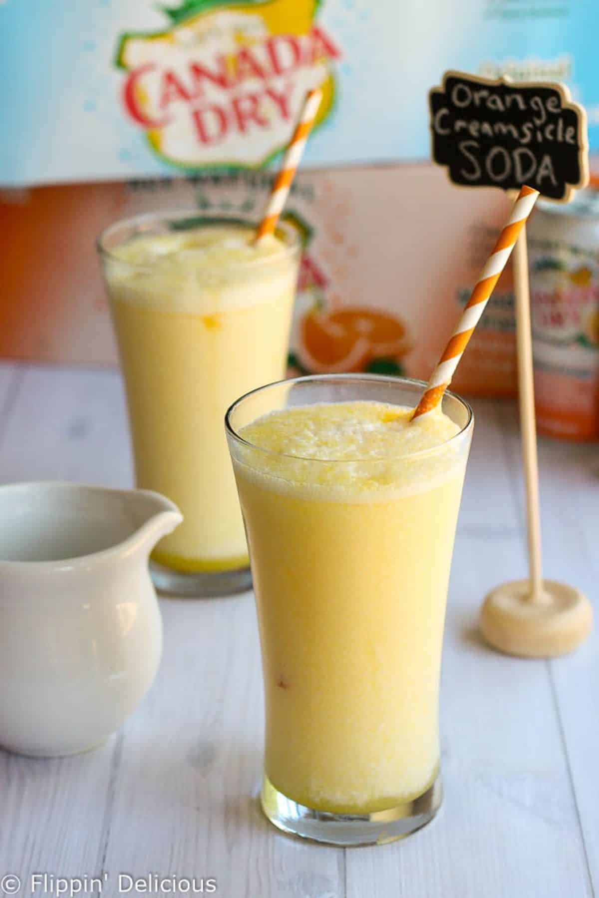 Refreshing Creamsicle Orange Italian Soda in two glass cups with straws.