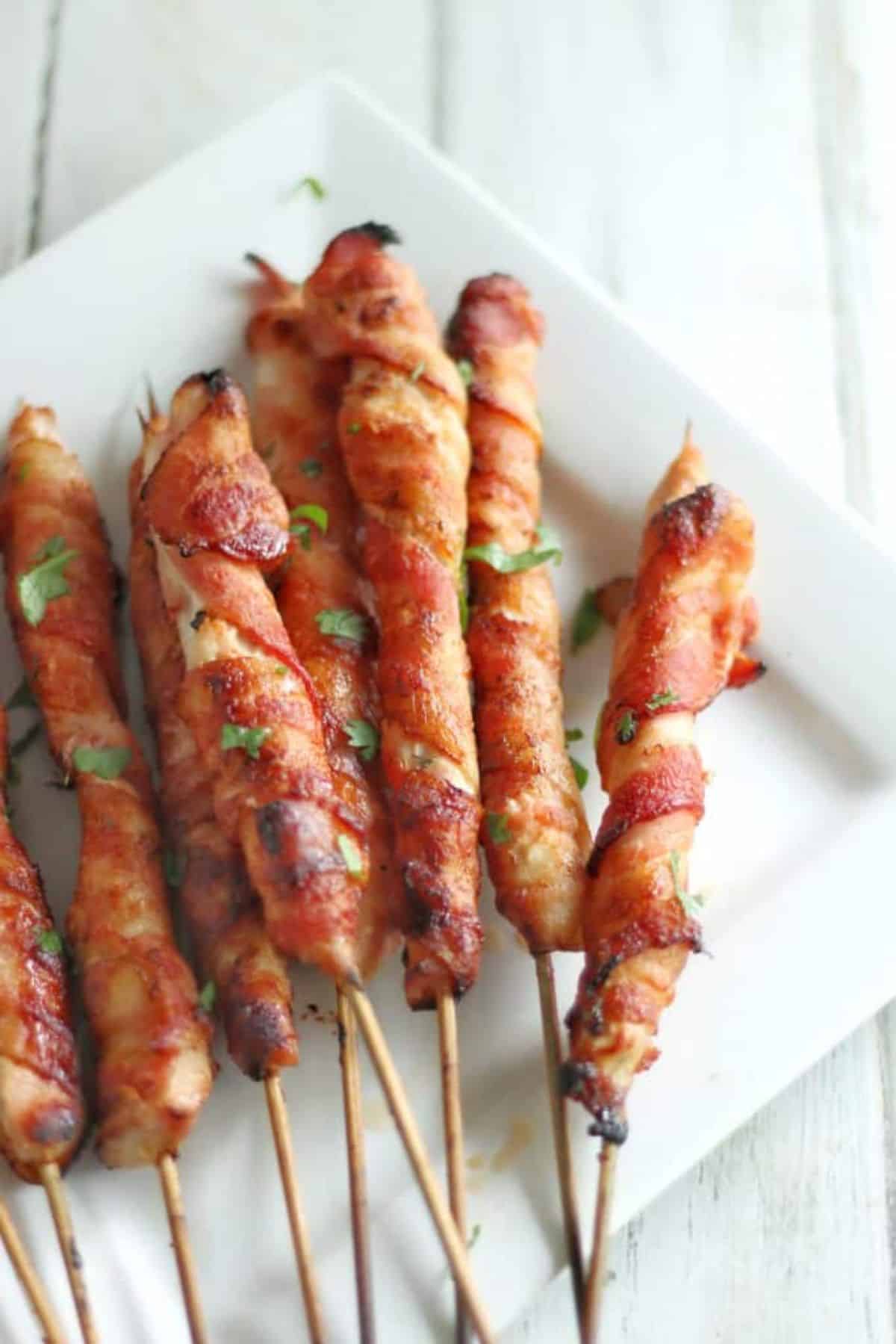 Scrumptious Bacon Wrapped Chicken Skewers on a white plate.