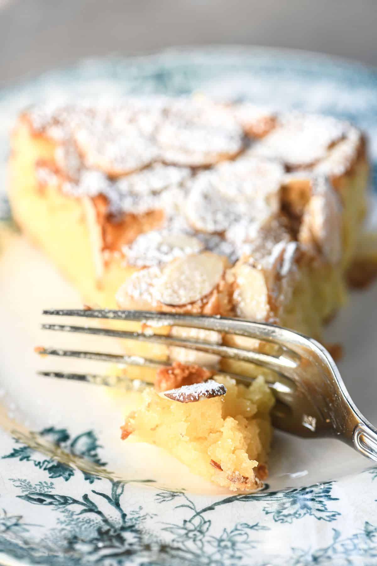 A piece of Almond Ricotta Cake on a plate with a fork.